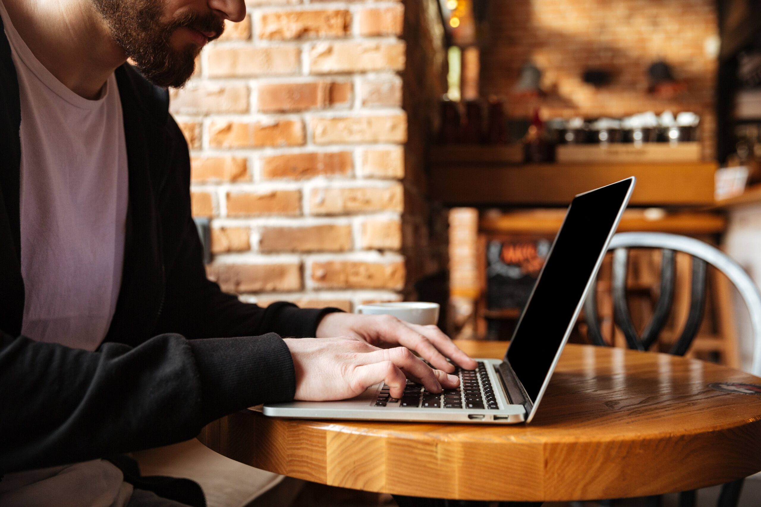 Young professional working on laptop in a cafe